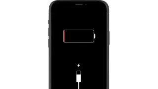 Czarny ekran telefonu z ikoną rozładowanej baterii i symbolem ładowania. Telefon się nie ładuje.