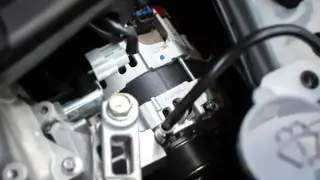 Wymiana sprzęgła alternatora w samochodzie. Widoczny element układu elektrycznego pojazdu, gotowy do montażu.